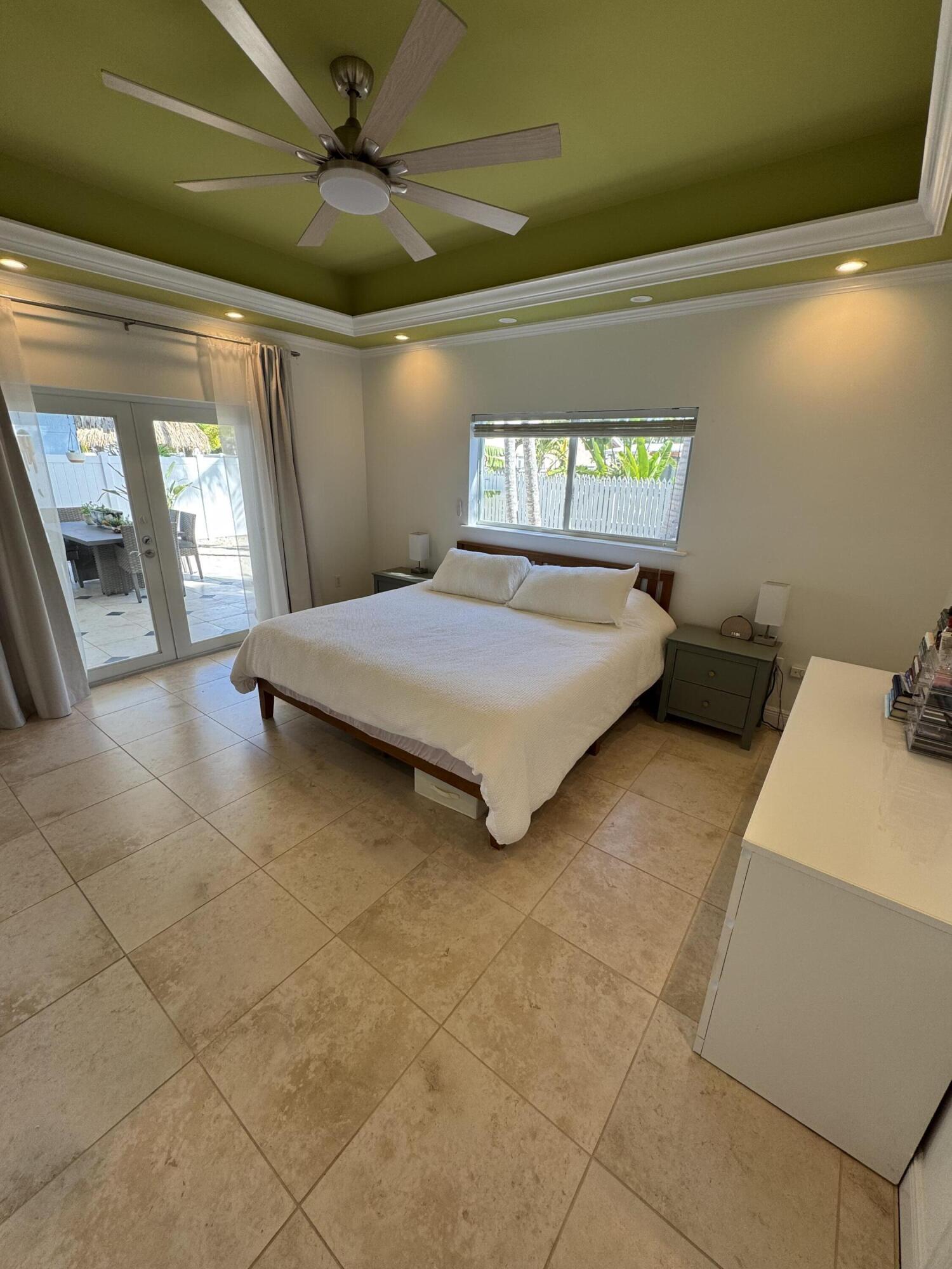 118 1st Street Key Largo, FL 33037 - Photo 2 of 10 a spacious bedroom with a bed and a chandelier