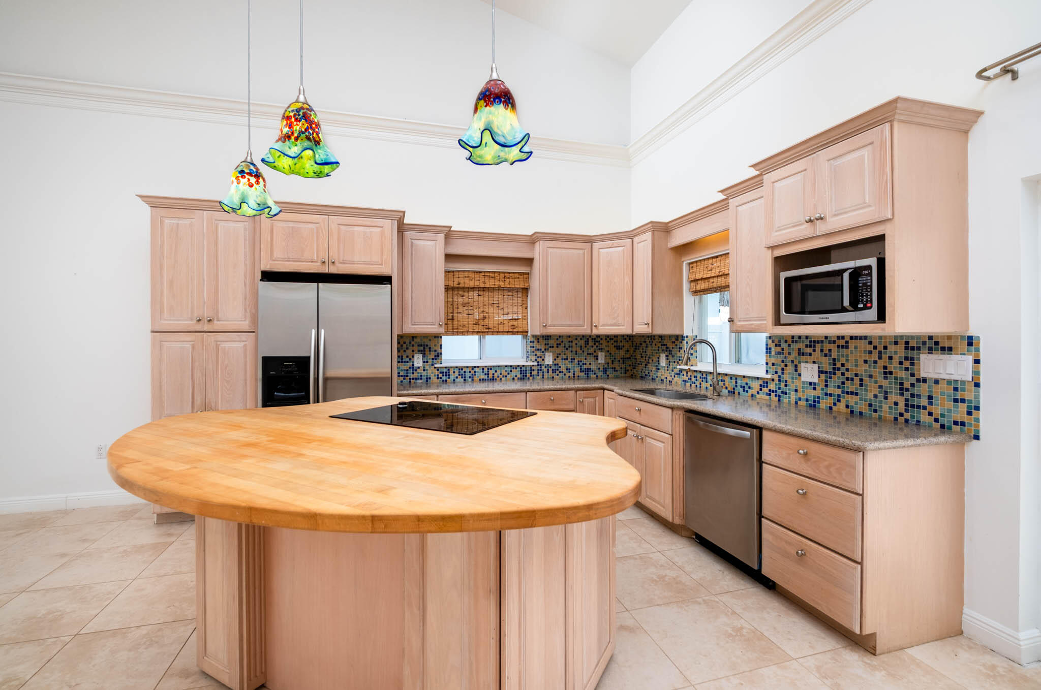 118 1st Street Key Largo, FL 33037 - Photo 6 of 25 a kitchen with stainless steel appliances kitchen island wooden cabinets a stove a sink and a microwave