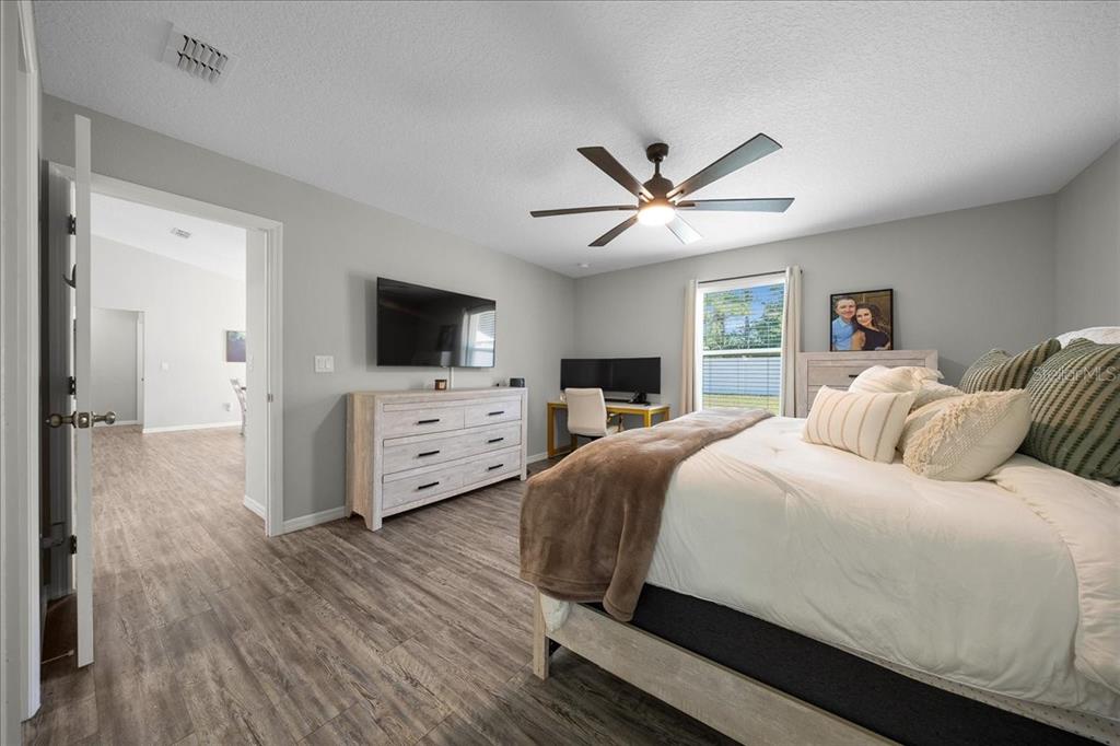13 Teak Loop Place Ocala, FL 34472 - Photo 29 of 36 a bedroom with a large bed a flat tv screen and a dresser