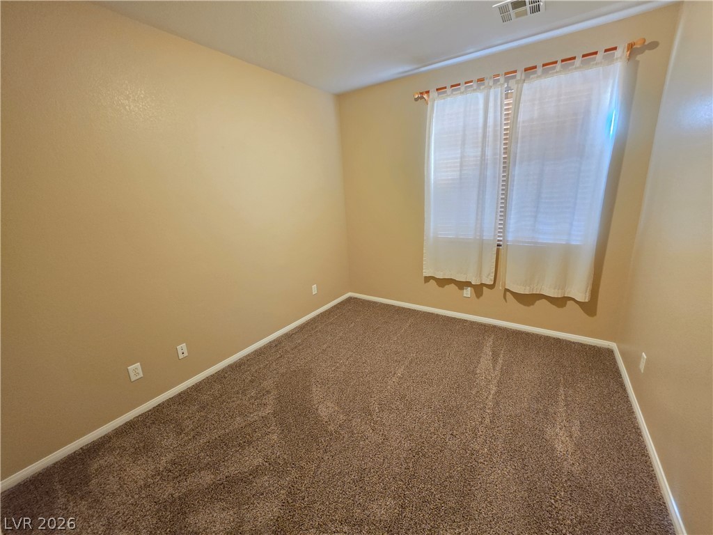 209 Opera House Street Henderson, NV 89012 - Photo 21 of 45 Plush carpeting anchors this versatile room under high ceilings and a wide window.