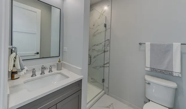 a bathroom with a granite countertop sink toilet and shower