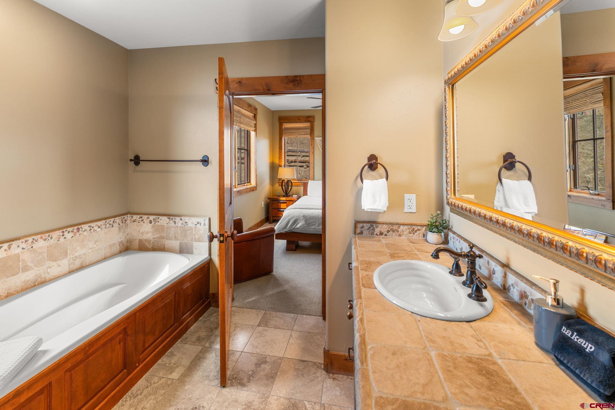 621 Gothic Road, Unit 2A Crested Butte, CO 81225 - Photo 18 of 34 a spacious bathroom with a tub sink and mirror