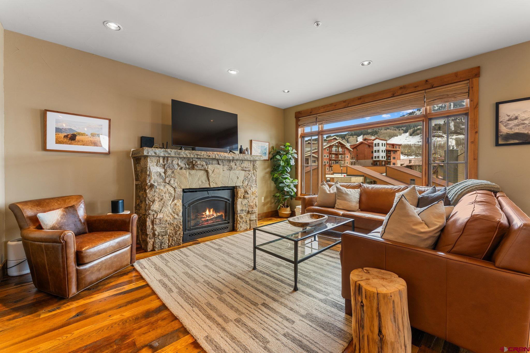 621 Gothic Road, Unit 2A Crested Butte, CO 81225 - Photo 5 of 34 a living room with furniture a flat screen tv and a fireplace