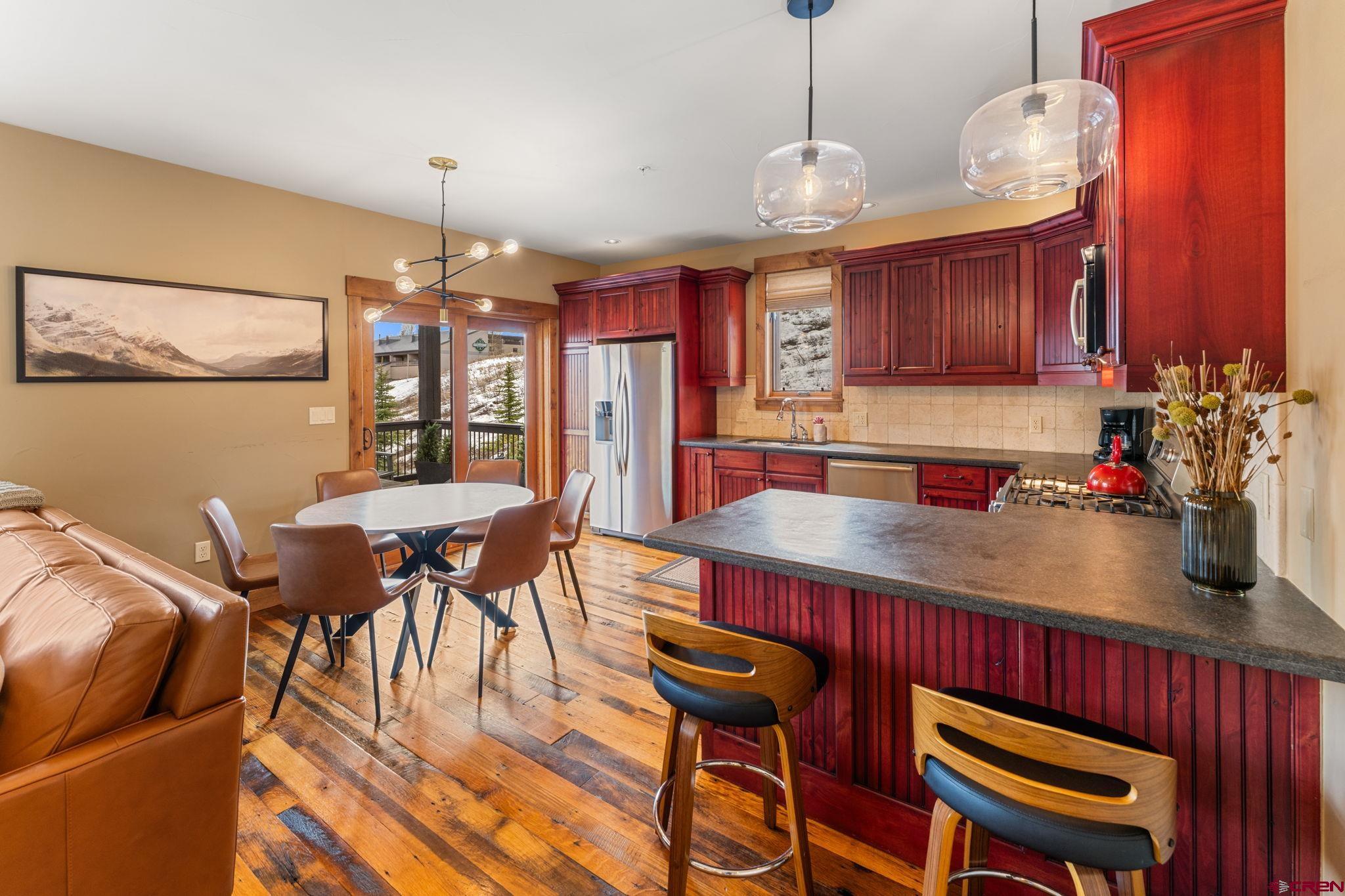 621 Gothic Road, Unit 2A Crested Butte, CO 81225 - Photo 7 of 34 a view of a dining room with furniture a chandelier and wooden floor