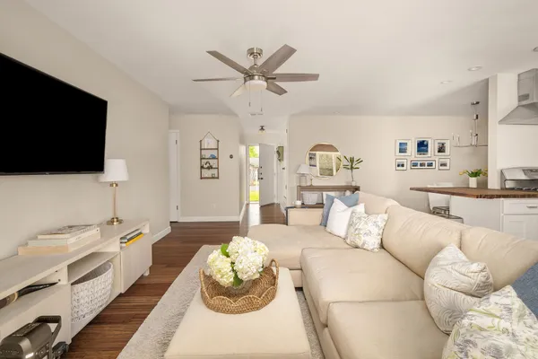 a living room with furniture a flat screen tv and a large window