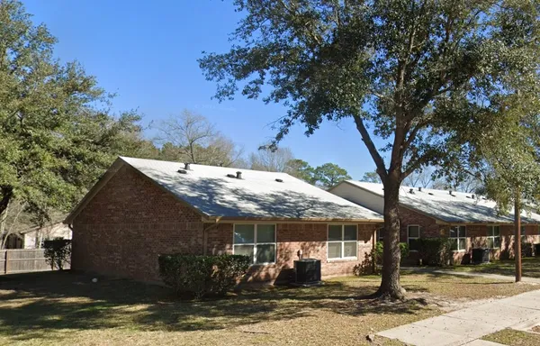 a front view of a house with a tree