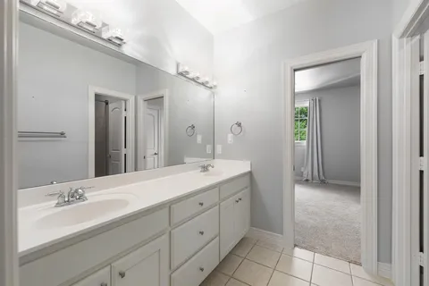 a en suite bathroom with a double vanity sink and a mirror