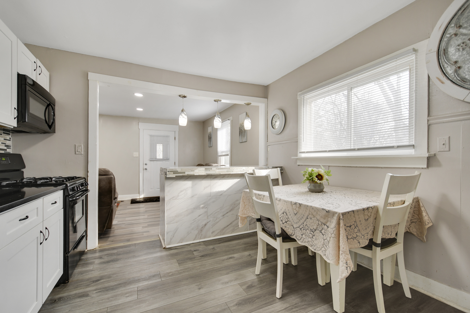 3737 Rose Manor Terrace Markham, IL 60428 - Photo 7 of 19 a kitchen with a dining table chairs and white cabinets