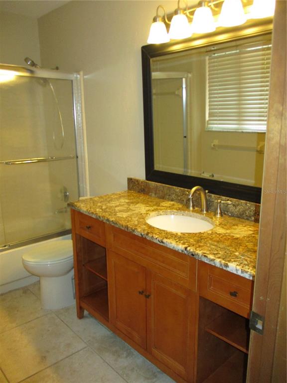 900 Southwest 62nd Boulevard, Unit D23 Gainesville, FL 32607 - Photo 16 of 37 a bathroom with a granite countertop sink toilet and shower