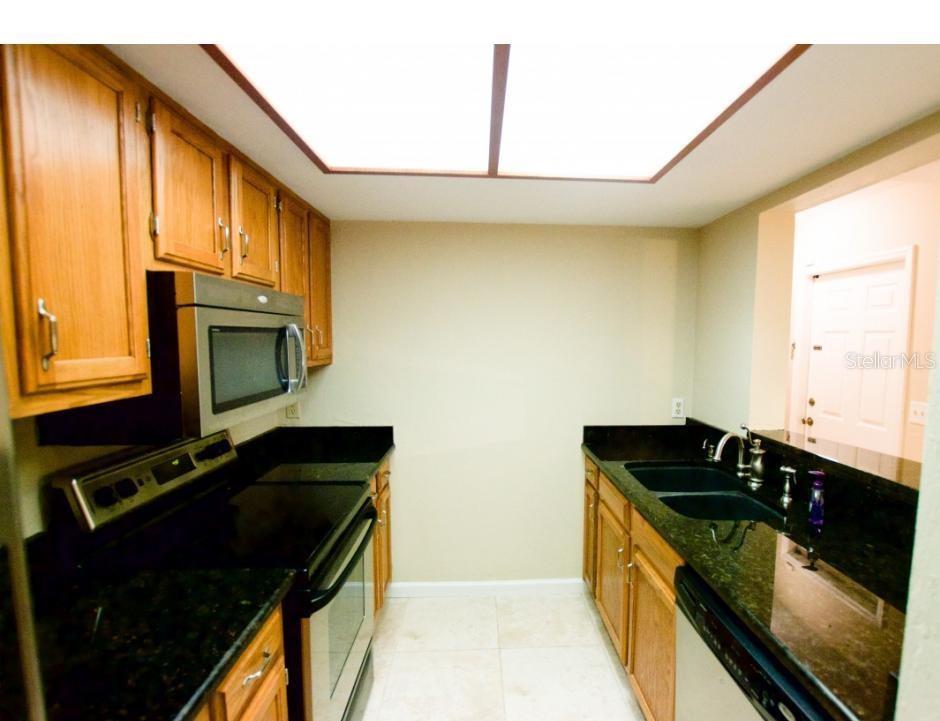 900 Southwest 62nd Boulevard, Unit D23 Gainesville, FL 32607 - Photo 2 of 37 a kitchen with granite countertop cabinets and black appliances