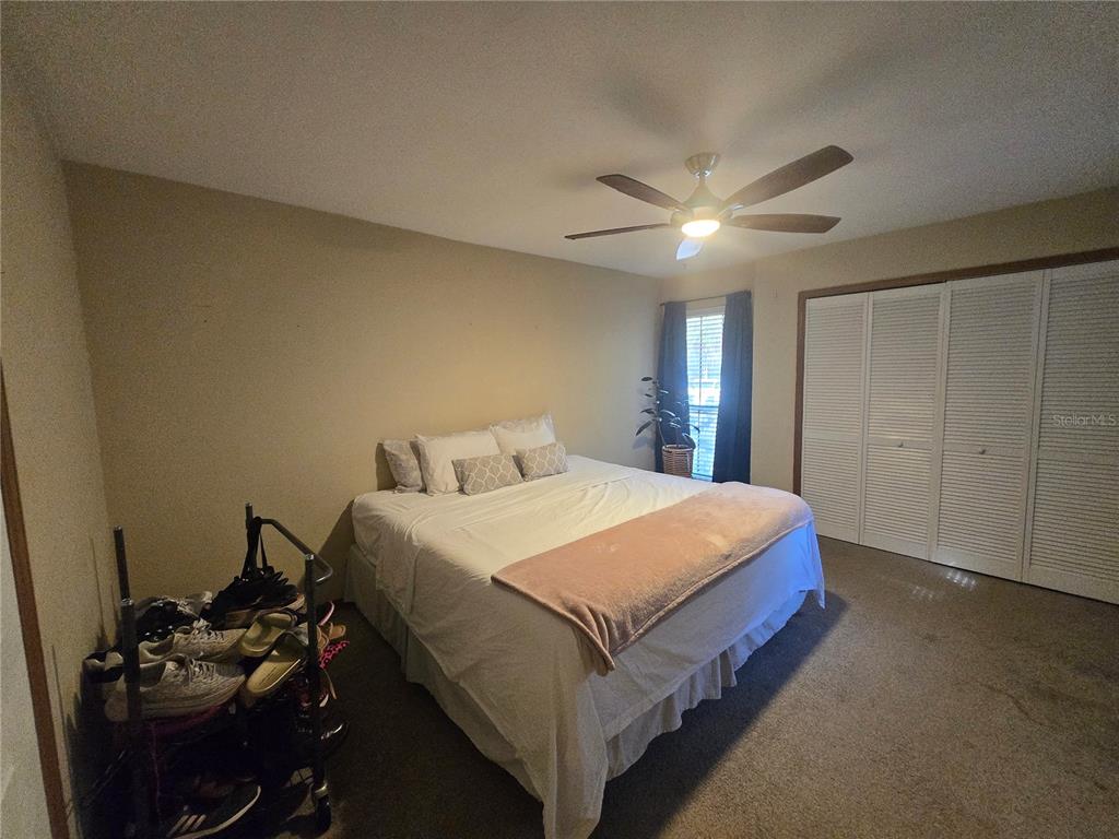 900 Southwest 62nd Boulevard, Unit D23 Gainesville, FL 32607 - Photo 35 of 37 a spacious bedroom with a bed and a ceiling fan