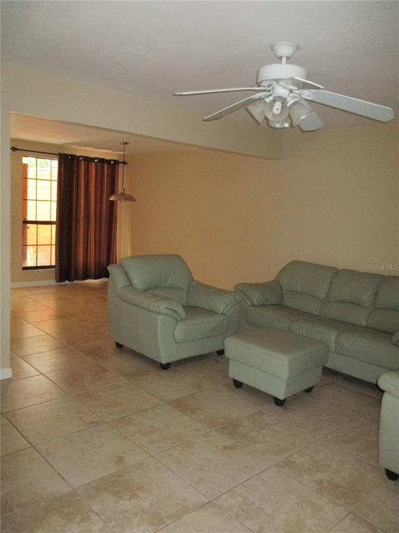 900 Southwest 62nd Boulevard, Unit D23 Gainesville, FL 32607 - Photo 9 of 37 a living room with furniture and chandelier