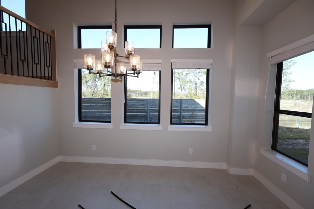 18603 Rumba Court Conroe, TX 77302 - Photo 5 of 15 an empty room with windows and chandelier