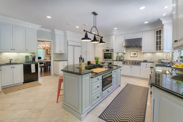 a kitchen with stainless steel appliances granite countertop a stove oven and white cabinets