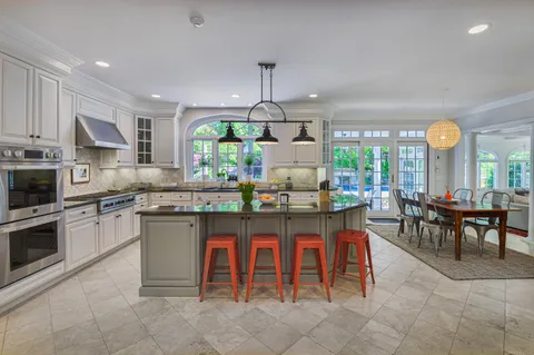 a kitchen with granite countertop a sink dining table and chairs