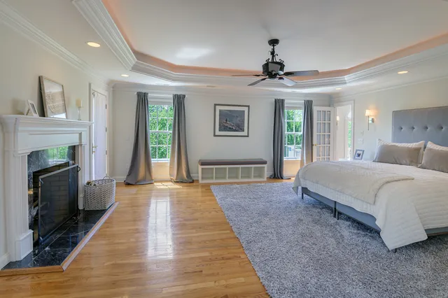 a spacious bedroom with a balcony a bed and a chandelier