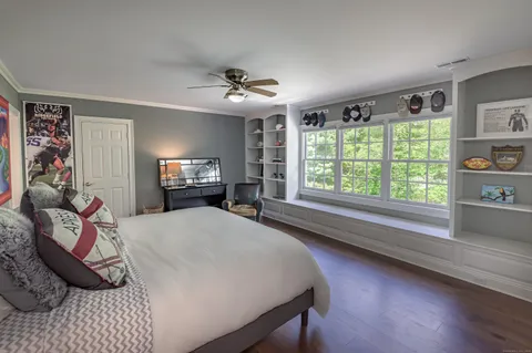 a spacious bedroom with a bed a dresser and a chandelier