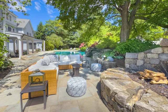 a view of a patio with table and chairs potted plants and large tree