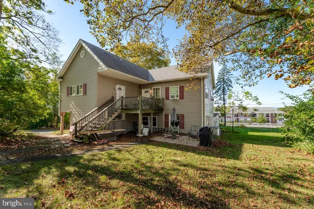 a view of a house with backyard and trees