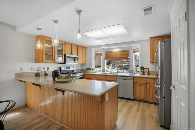 a kitchen with stainless steel appliances granite countertop a stove a sink dishwasher a refrigerator and a microwave oven