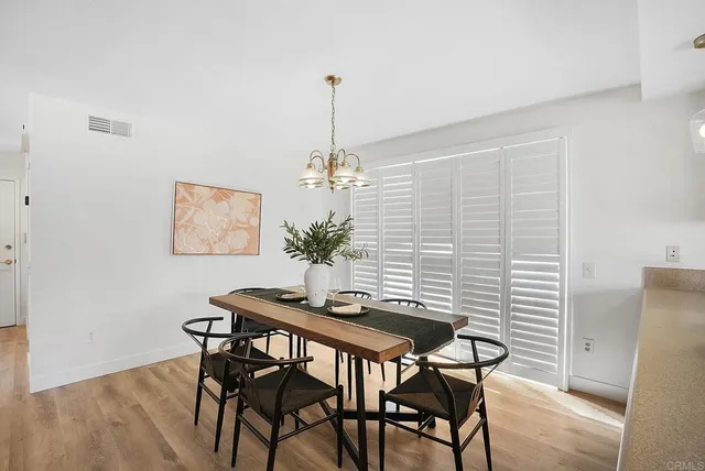 a kitchen with a sink dishwasher a stove and white cabinets with wooden floor