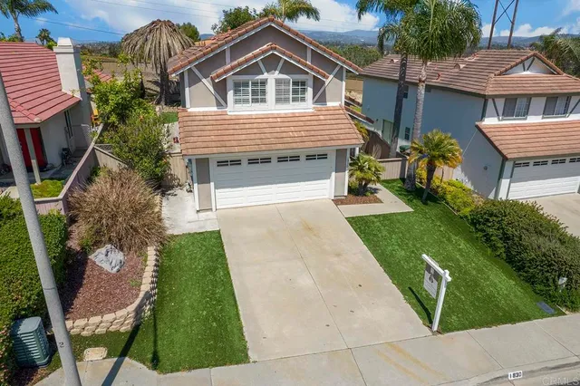 an aerial view of residential houses with outdoor space and parking