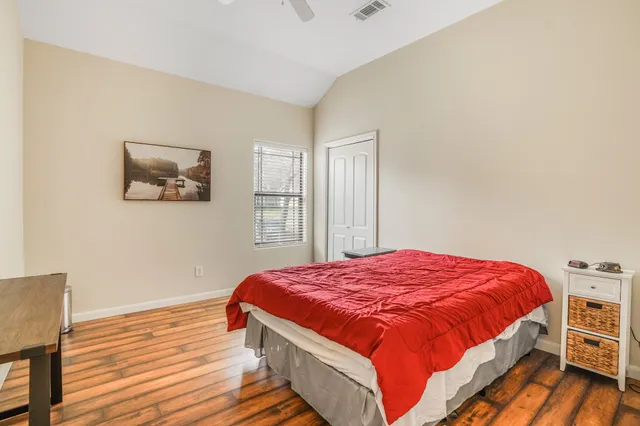 a bedroom with a bed and wooden floor