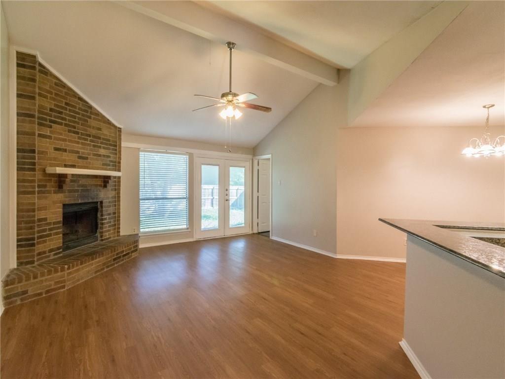 1023 Cresthaven Drive Lancaster, TX 75134 - Photo 1 of 1 an empty room with wooden floor fireplace and windows