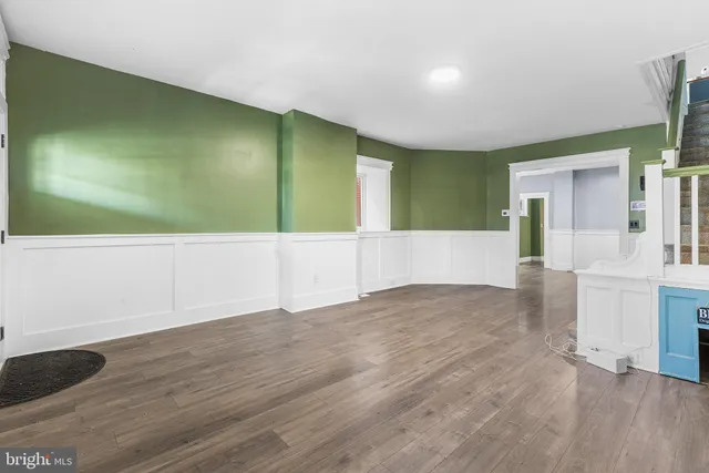 a view of empty room with wooden floor