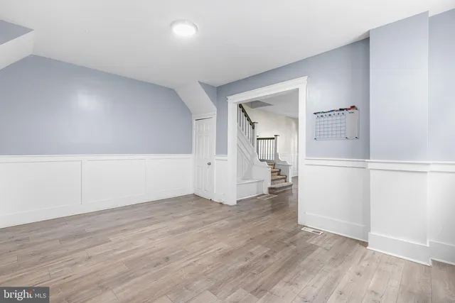 an empty room with wooden floor and entrance