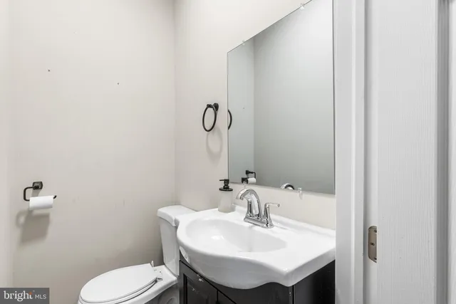 a bathroom with a toilet sink and mirror