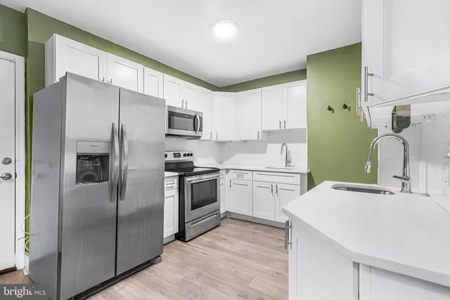 a kitchen with a sink stainless steel appliances and cabinets