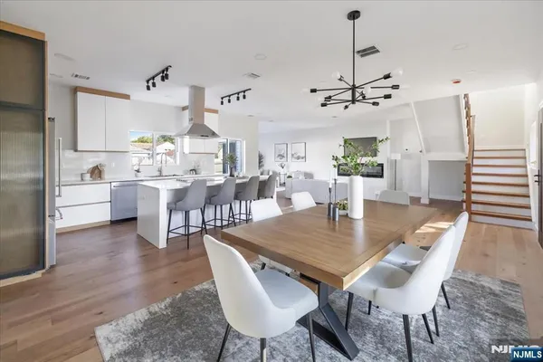 a view of a dining room and livingroom with furniture wooden floor a chandelier