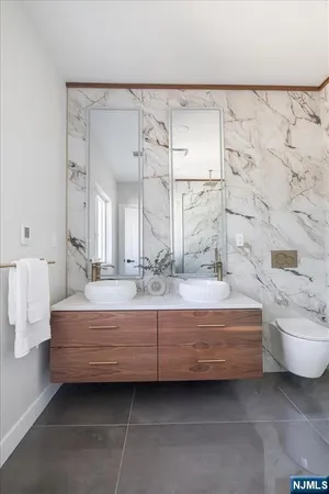 a bathroom with a double vanity sink toilet and shower