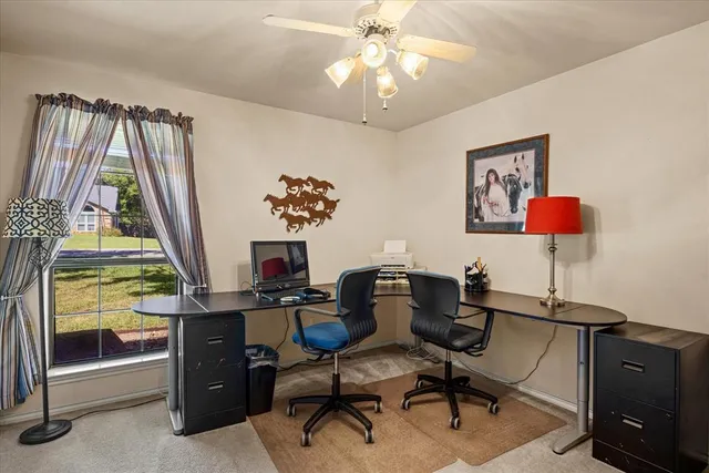 a view of a workspace with furniture and a window