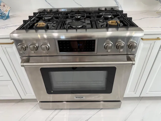 a stove top oven sitting inside of a kitchen
