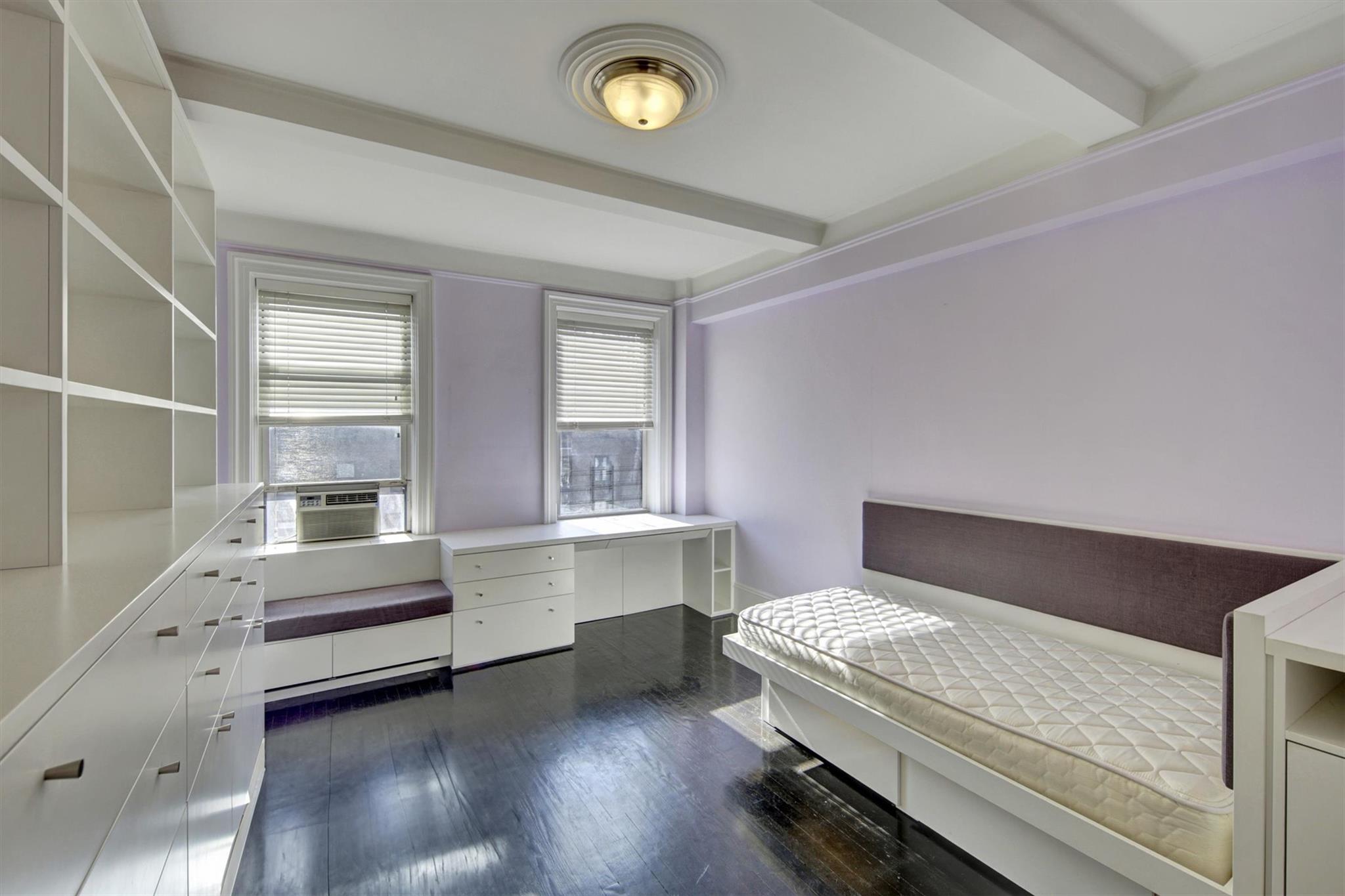 65 East 96th Street, Unit 16B Manhattan, NY 10128 - Photo 13 of 45 Bedroom with beamed ceiling, dark hardwood / wood-style floors, built in desk, and cooling unit