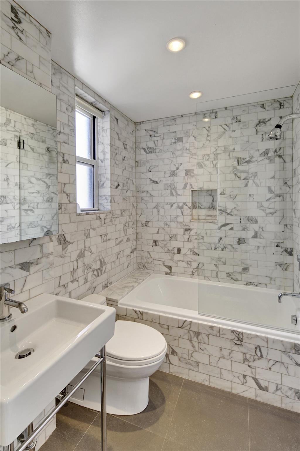 65 East 96th Street, Unit 16B Manhattan, NY 10128 - Photo 14 of 45 Full bathroom featuring tiled shower / bath, toilet, sink, and tile walls