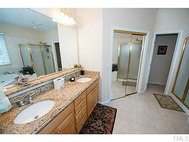 672 Seastone Street Raleigh, NC 27603 - Photo 11 of 23 Master bathroom with dual sink granite vanity, whirlpool tub, walk-in closet and tile.
