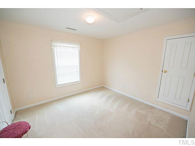 672 Seastone Street Raleigh, NC 27603 - Photo 19 of 23 Secondary bedroom with door to walk-in attic.