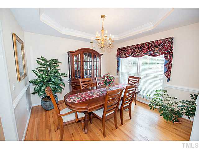 672 Seastone Street Raleigh, NC 27603 - Photo 6 of 23 Formal dining room with tray ceiling, chair rail molding and hardwoods.