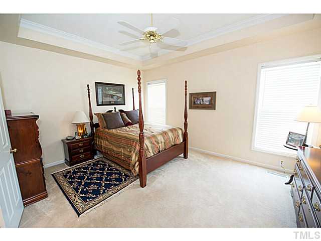 672 Seastone Street Raleigh, NC 27603 - Photo 10 of 23 First floor master bedroom with tray ceiling, fan and crown molding.