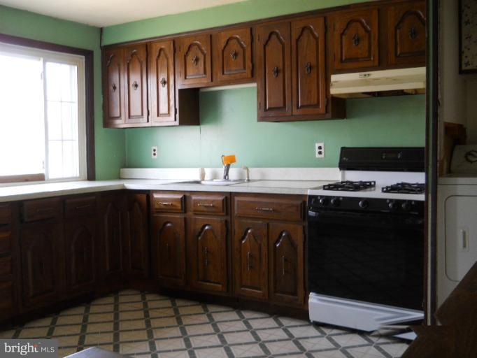 8186 Mid Haven Road Dundalk, MD 21222 - Photo 14 of 21 a kitchen with stainless steel appliances a stove a sink and a microwave
