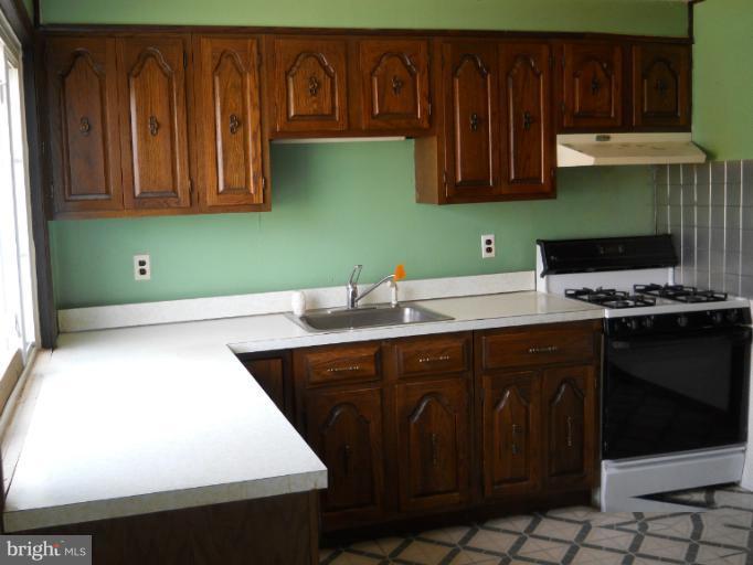 8186 Mid Haven Road Dundalk, MD 21222 - Photo 10 of 21 a kitchen with kitchen island a sink cabinets and appliances