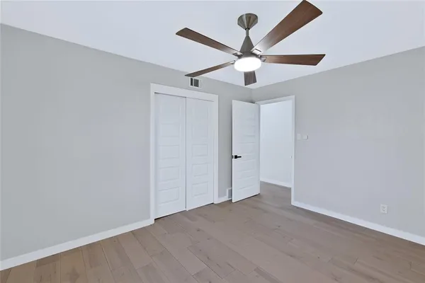 an empty room with a window and a fan