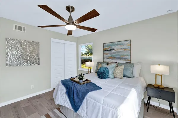 a bedroom with a bed and a lamp on the dresser