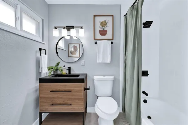 a bathroom with a toilet sink vanity and mirror