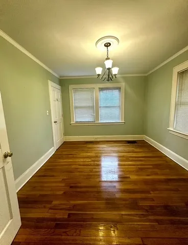 a view of a room with wooden floor and painting on the wall