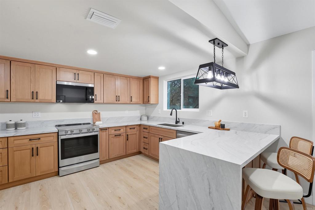 24350 Watt Road Ramona, CA 92065 - Photo 2 of 26 a kitchen with a sink a stove a microwave and cabinets