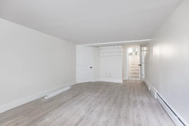 a view of an empty room with wooden floor